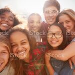 Teenage school friends smiling to camera, close up